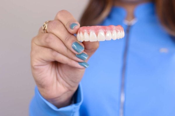 Woman holding dentures